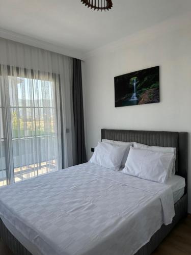 a bedroom with a large white bed with a window at Olive villas in Fethiye