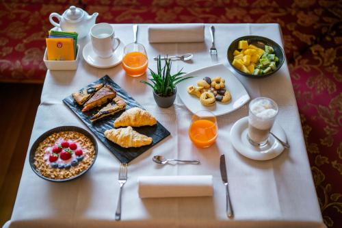 a table with breakfast foods and drinks on it at Hotel Des Alpes in Cortina dʼAmpezzo