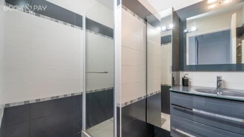 bagno con doccia in vetro e lavandino di Appartement 60m² à 20 min de Paris a Romainville