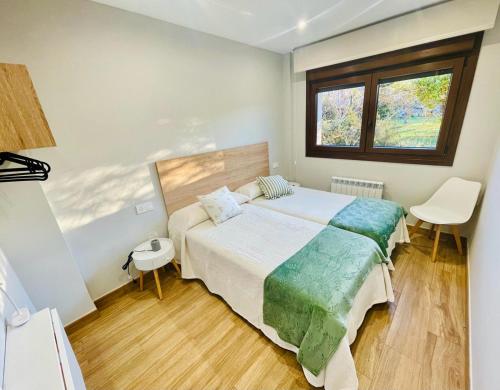 a bedroom with a large bed and a window at Las Casitas de Cueva in Cueva
