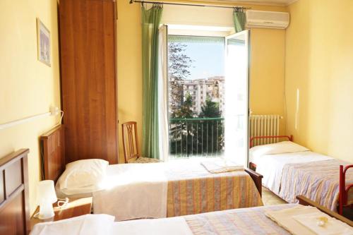 a hotel room with two beds and a window at Albergo Da Peppino in Poggio Mirteto