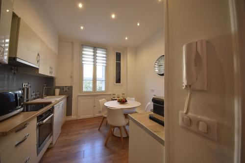 une cuisine avec une table et une petite table. dans l'établissement 4P et Studio avec Terrasse, 500m Palais, Charme Bourgeois, à Cannes