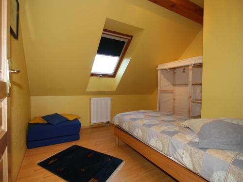 um quarto com uma cama e uma janela em Holiday flat on small holiday farm with indoor pool many activities Kindwiller em Pfaffenhoffen