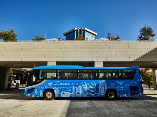a blue bus is parked in a parking lot at Kansai Airport Washington Hotel in Izumi-Sano