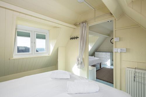 a small bedroom with a bed and a window at Cable Cottage in Llanrhyddlad