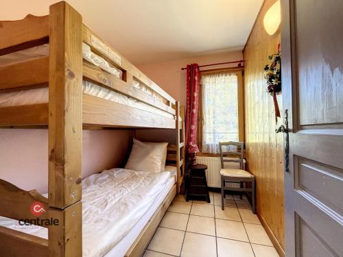 une chambre avec deux lits superposés et une fenêtre dans l'établissement Clos 11 - appartement - 8 pers - proche centre, aux Gets
