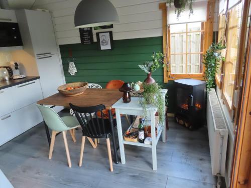 eine Küche mit einem Tisch, Stühlen und einem Herd in der Unterkunft Tiny Botanic House in Tzummarum