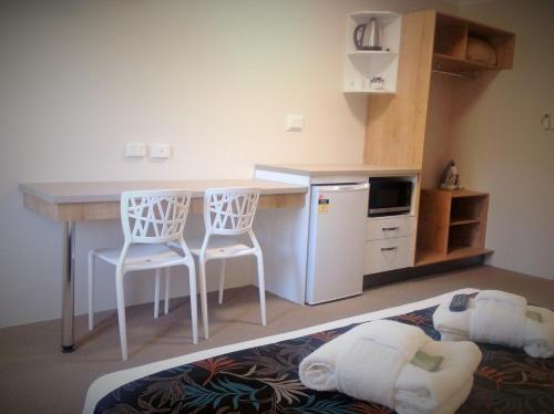 a kitchen with a table and chairs and a refrigerator at Castle Crest Motel in Townsville