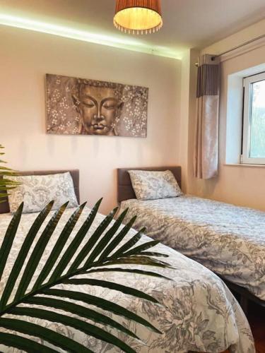 a bedroom with two beds and a large head on the wall at Casa Estrela in Alvaiázere