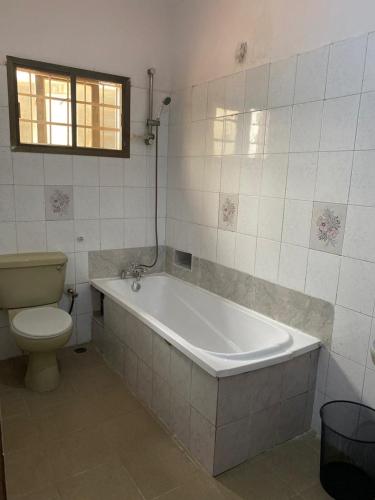 a bathroom with a bath tub and a toilet at Kath's Hub in Lagos