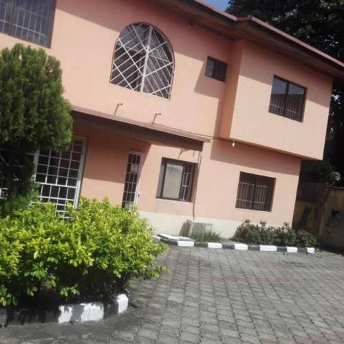 a house with a brick driveway in front of a building at Kath's Hub in Lagos