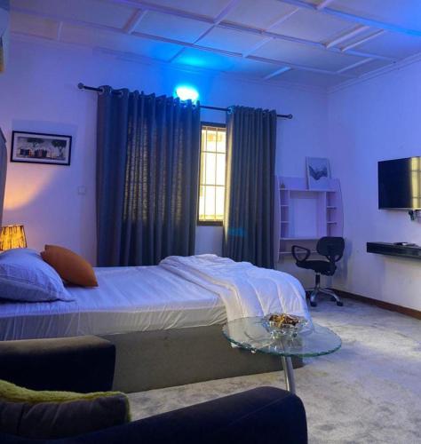 a bedroom with a bed and a glass table at Kath's Hub in Lagos