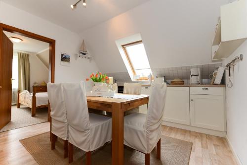 een keuken en eetkamer met een houten tafel en stoelen bij Haus Bonken - a72764 in Wyk auf Föhr