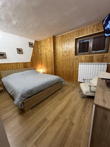 a bedroom with a bed and a couch in it at Mountain View Apartment with Garden, Roccaraso in Roccaraso