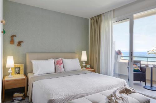 a bedroom with a bed and a view of the ocean at Afitis Boutique Hotel in Afitos