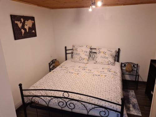 - une chambre avec un lit avec un cadre en métal et des oreillers dans l'établissement la chêneraie appart Lapin, à Ychoux