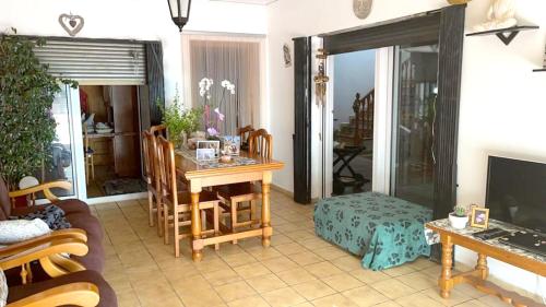 a living room with a table and chairs and a television at 3 bedrooms villa with private pool enclosed garden and wifi at Valencia in Marchuquera