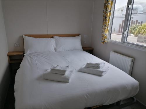 a bedroom with a white bed with towels on it at Ivy cottage - Parking and outdoor area in Kent