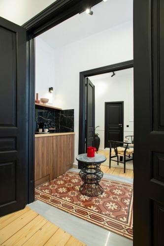 a living room with a table and a kitchen at Stoa House Airport in Koropíon