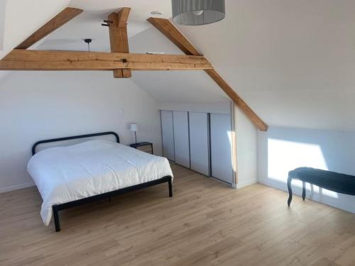 a bedroom with a bed and a wooden floor at « La Suisse » Courcelloise in Courcelles-Sapicourt