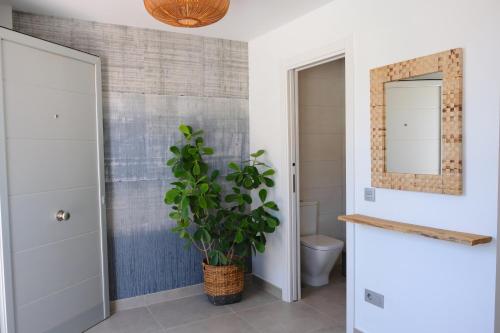 a bathroom with a toilet and a potted plant at Casa Mara Médano in El Médano