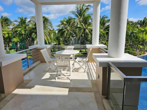 a balcony with a table and chairs next to the water at Hua Hin Blue Lagoon in Cha Am