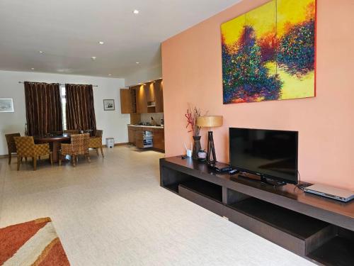 a living room with a flat screen tv on a wall at Hua Hin Blue Lagoon in Cha Am