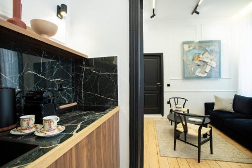 a kitchen and living room with a black counter top at Stoa House Airport in Koropíon