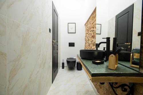 a bathroom with a black sink and a mirror at Stoa House Airport in Koropi