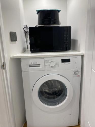 a microwave sitting on top of a washing machine at nana house in London