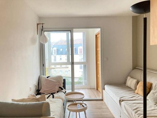 uma sala de estar com um sofá e uma mesa em La Grande Coloc - Superbe T4 refait à neuf em Poitiers
