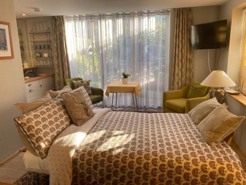 ein Schlafzimmer mit einem Bett, einem Sofa und einem Fenster in der Unterkunft Summer house studio in Cheltenham