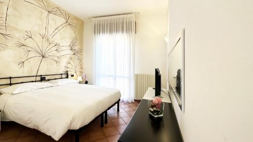 ein Schlafzimmer mit einem Bett und einem TV auf einem Tisch in der Unterkunft Int 12 - Appartamento dei Gerani in Bologna