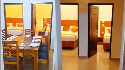 un comedor con mesa y una habitación con 2 camas en CJ Cottage Munnar - Near Attukal Waterfalls, Athukad Tea Estate (CJ Hotels & Resorts), en Devikolam