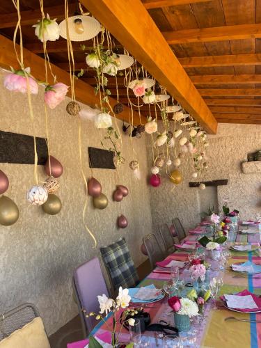 a long dining room with a long table with flowers at Mas de JANNE in Cléon-dʼAndran