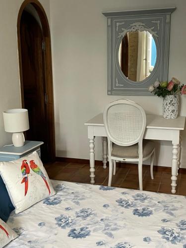 a bedroom with a desk and a bed with a pillow at Mas de JANNE in Cléon-dʼAndran