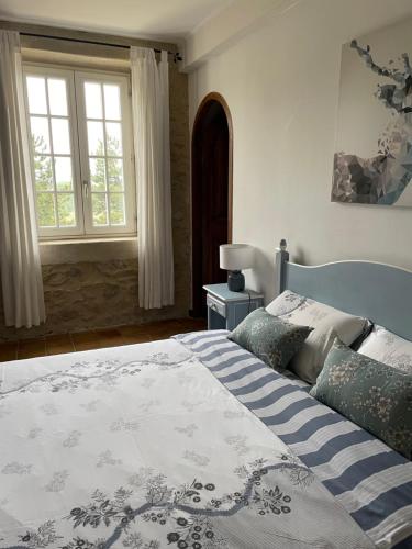 1 dormitorio con 1 cama con manta azul y blanca en Mas de JANNE, en Cléon-dʼAndran