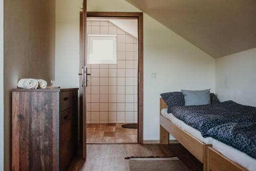 Dormitorio pequeño con cama y ducha en penzion V Růžích en Hroznová Lhota