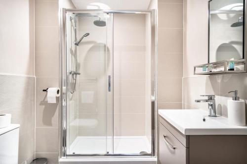 a bathroom with a shower and a sink at Spacious & Bright 2 Bed Apartment in Manchester in Manchester