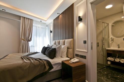 um quarto com uma cama e uma casa de banho com um lavatório em VALİDE RESİDENCE em Istambul