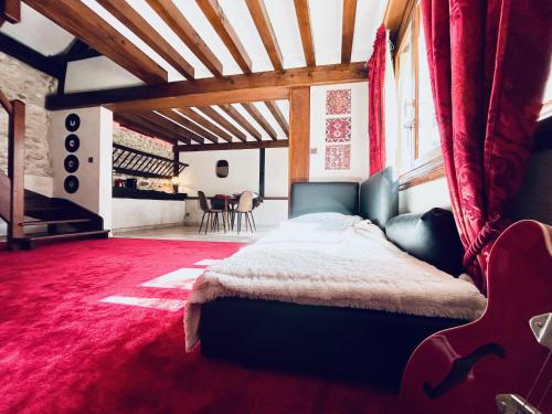 a bedroom with a bed with a red carpet at LIAGE - La Maison qui relie in Saint-Marcel