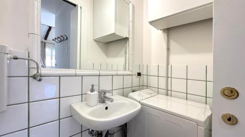 Un baño blanco con lavabo y espejo. en Int 6 - Suite Marco by Residence San Luca, en Bolonia