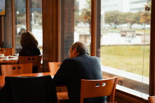 a man sitting at a table looking out a window at Sancho Ramirez in Pamplona