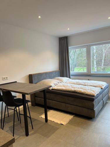 a bedroom with a bed and a table and a window at Apartment 170 in Bad Münstereifel