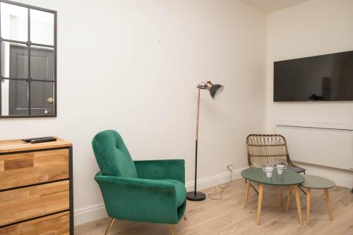 uma sala de estar com uma cadeira verde e uma mesa em Grand studio industriel dans le centre historique em Poitiers