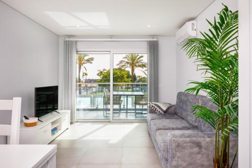a living room with a couch and a tv at Kasino II 1º A in Monte Gordo