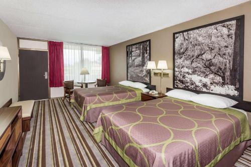 A bed or beds in a room at Super 8 by Wyndham Valdosta Mall