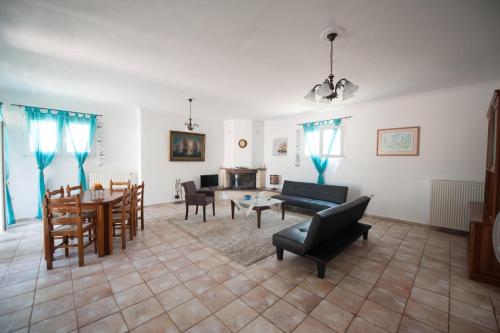 ein Wohnzimmer mit einem Sofa, einem Tisch und Stühlen in der Unterkunft S&C Kosmos Beach Resort in Roda