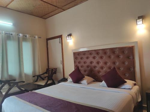 um quarto com uma cama grande e uma grande cabeceira. em Hotel Tawang em Tawang