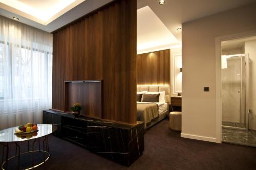 a hotel room with a bedroom with a bed and a table at VALİDE RESİDENCE in Istanbul
